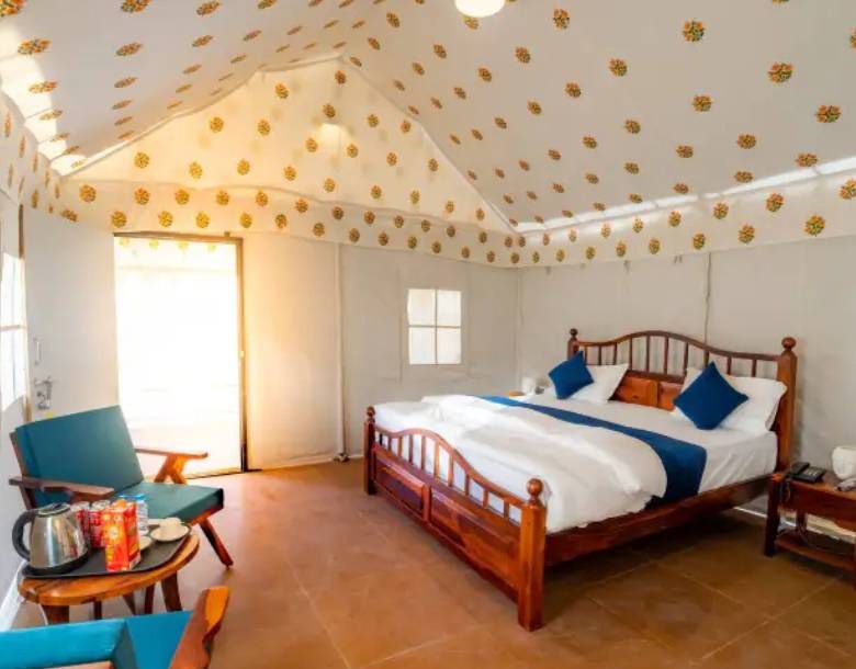Swiss tent bedroom with wooden bed and blue cushions