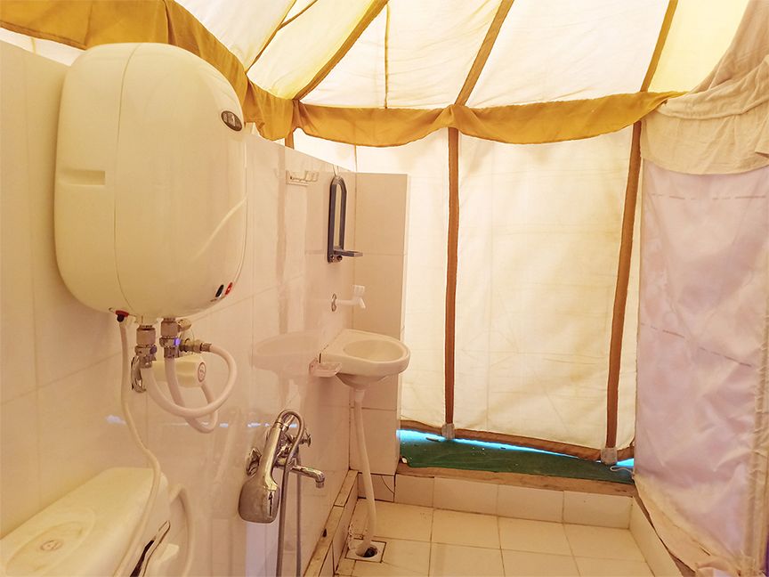 Tent bathroom amenities with geyser and wash basin